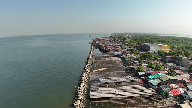 Drone footage reveals Cavite City&rsquo;s coastal bay, where informal settlers line the breakwater and seawall. This powerful aerial scene captures urban density, resilience