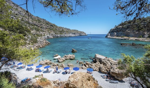 Beach umbrellas and sunbeds, turquoise waters, Anthony Quinn Bay, Faliraki, Rhodes, Dodecanese, Greece