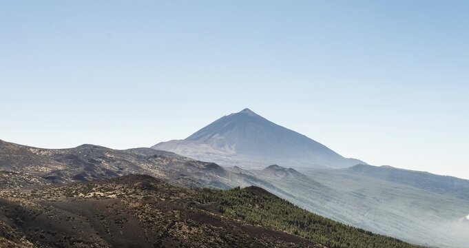 Volcanic landscape and a pine forest with Pico del Teide, 3718m, and small craters, Parque Nacional de las Ca&ntilde;adas del Teide, Teide National Park, UNESCO World Heritage Site, Tenerife, Canary Islands, Spain
