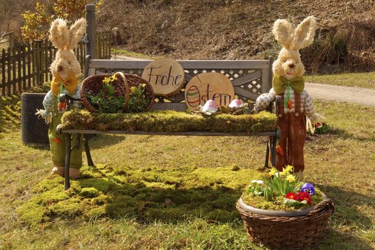Easter bunny, two, bench covered with moss, Easter egg, flower basket, tree slice inscribed with Happy Easter, door stone, Upper Franconia, Franconian Switzerland, Franconia, Bavaria, Germany