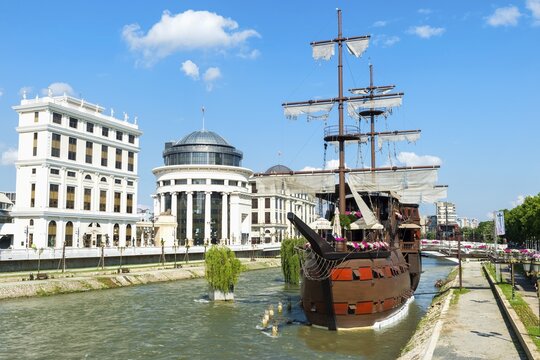 Galleon ship restaurant and bar on Vardar River, Government buildings behind, Skopje, Macedonia