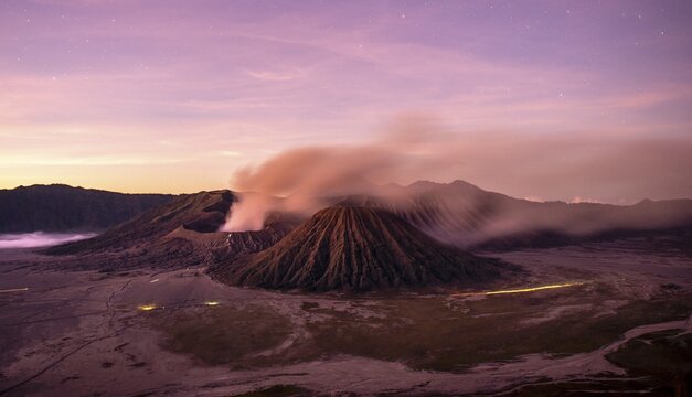 Volcanic landscape at sunrise with starry sky, smoking volcano Gunung Bromo, with Mt. Batok, Mt. Kursi, Mt. Gunung Semeru, National Park Bromo-Tengger-Semeru, Java, Indonesia