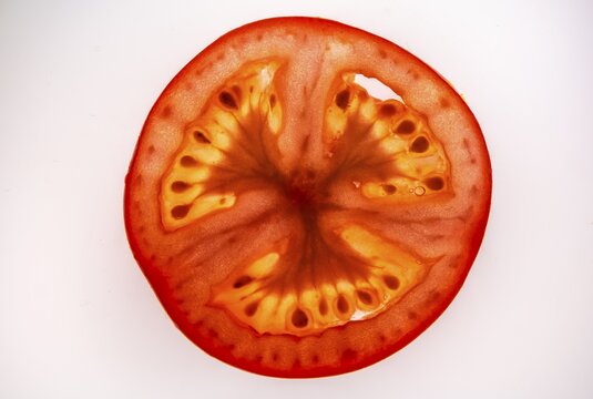 Slice of a tomato, fruit vegetables, white background, food photography