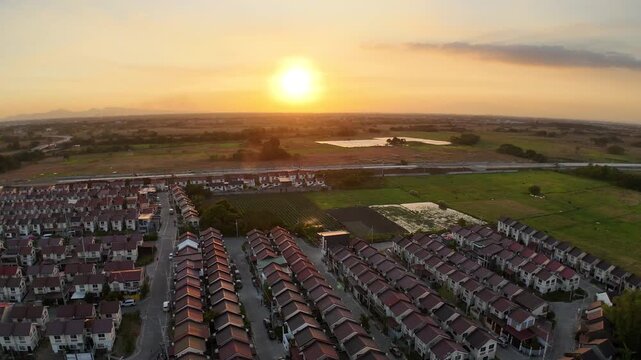 Golden sunset bathes Tierra Vista and Nueva Estancia in Cavite, Philippines, as a drone gracefully orbits above homes and fields. This cinematic aerial captures peaceful suburban living