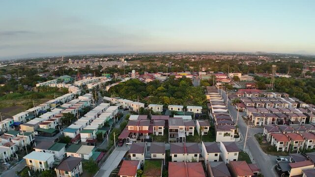 Golden sunset bathes Tierra Vista and Nueva Estancia in Cavite, Philippines, as a drone gracefully orbits above homes and fields. This cinematic aerial captures peaceful suburban living
