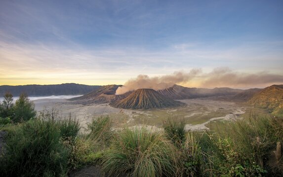 View of volcanic landscape, volcanoes at sunset, smoking volcano Gunung Bromo, Mt. Batok, Mt. Kursi, Mt. Gunung Semeru, Bromo-Tengger-Semeru National Park, Java, Indonesia