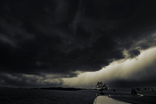 Road and meadows with thunderstorm sky in the background, Eggental, Ostallg&auml;u, Swabia, Bavaria, Germany