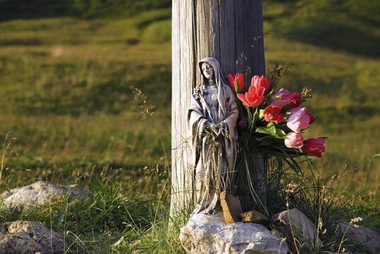 Madonna with tulips at a cross at the Passo Pordoi at sunset, province of Bolzano-Bozen, Italy, Europe