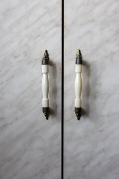 Wardrobe door handles on marble cabinet surface