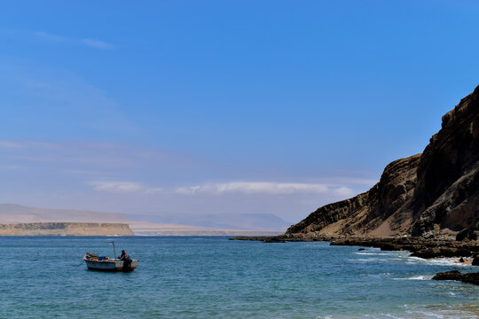 Boat in paracas beach peru, Mountain backgroud, blue sea sky blue clear
