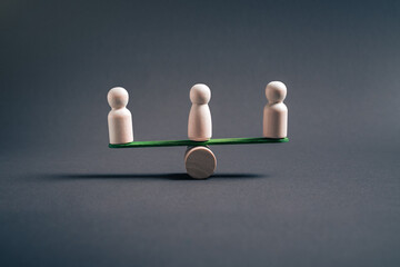 Obraz premium Collective balance and organizational stability concept with three wooden figures