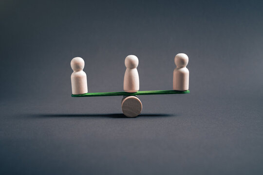 Collective balance and organizational stability concept with three wooden figures