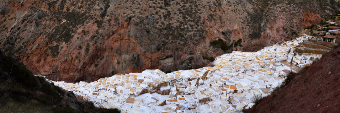 Terraced salt flats also known as Salineras de Maras, among the most picturesque tourist destinations in the Cusco region, Peru. view from above of the colorful reflective surfaces of the ponds
