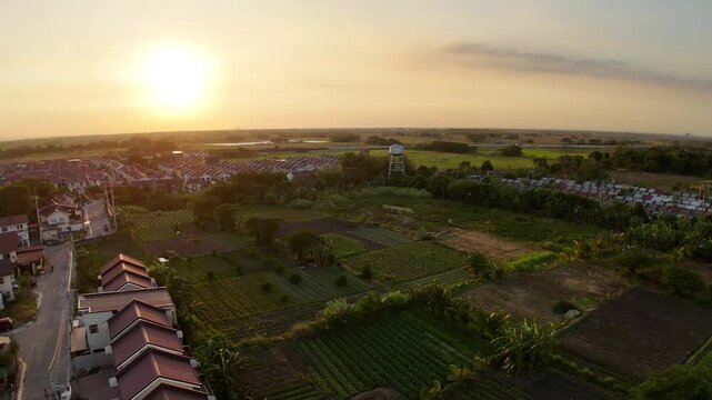 Golden sunset bathes Tierra Vista and Nueva Estancia in Cavite, Philippines as a drone gracefully orbits above homes and fields. This cinematic aerial captures peaceful suburban living.