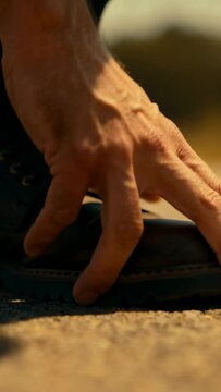 Man kneeling pressing shoe toe on pavement, activating animated pressure map for footwear design