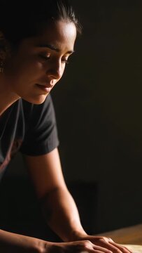 Woman pressing palms on dough, initiating smoothing motion to flatten round sheet for baking