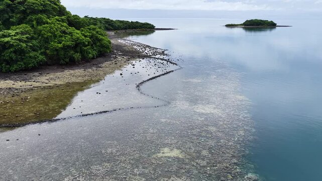 An ancient stone fish trap is found on a reef flat on a small, scenic island in Fiji. These simple traps, found throughout Fiji and the tropical Pacific islands, capture reef fish as the tide drops.