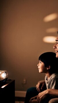 Watching Asian dad and son in casual clothing on couch, projector beam lighting wall, copy space