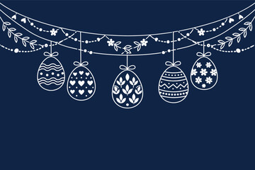 Fototapeta premium Decorative easter eggs hanging on floral garland with navy background