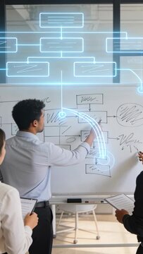 Vertical video: Sketching lead in pale shirt drawing board in room, overlay appearing to map nodes
