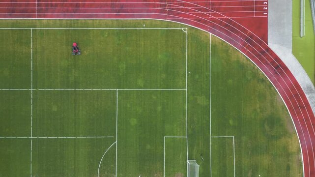 Aerial Top Down View of Mower Cutting Grass on Soccer Field