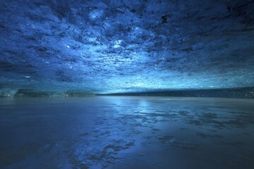 Fototapeta premium Ice cave interior showing a glacial meltwater pool under blue ice formations