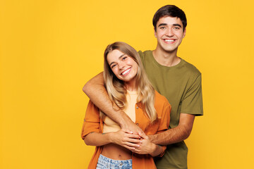 Young smiling calm couple two friends family man woman wear shirt casual clothes cuddle embrace...