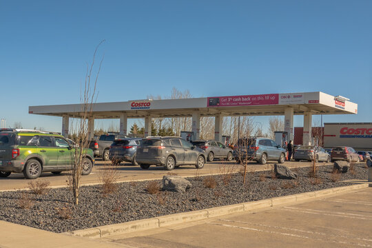 Calgary, Alberta, Canada. March 23, 2026. A busy line of vehicles queuing at a Costco Wholesale gasoline station on a clear, sunny day.
