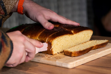 Slicing a fresh loaf of fluffy golden bread
