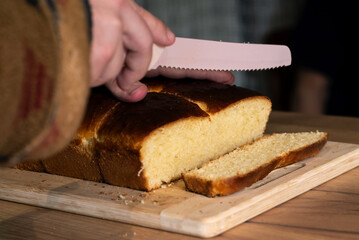 Slicing a fresh loaf of fluffy golden bread