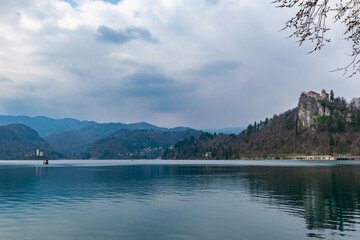Lake Bled landscape with church and castle under dramatic cloudy sky in Slovenia with calm water surface © Franziska Brueckmann