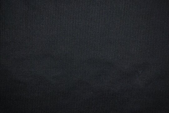 Black fine ribbed jersey knit textile texture dark fabric background