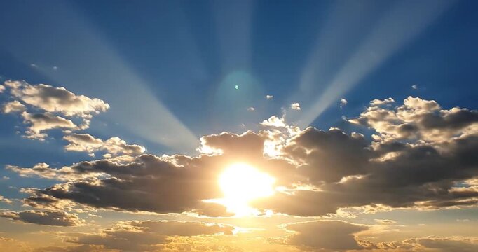 Sunbeams breaking through dramatic clouds in a blue sky