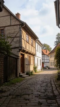 Camera tracking forward through cobblestone lane, revealing timber facades for travel promo