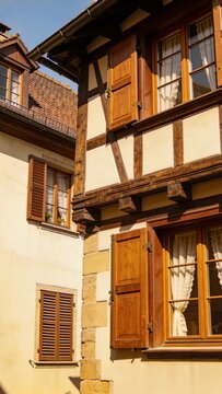 Vertical video: Tilting camera revealing right timber facade on narrow street, to show shutters