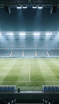 Vertical video: Floodlights brightening, pitch and dugouts glowing at stadium, preparing for match