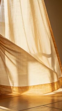 Vertical video: Cream curtain billowing in window breeze shifting light showing gold hem for design