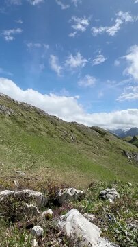 Timelapse view of Alpine mountains from a different perspective, featuring rolling peaks and drifting clouds over a vast mountainous landscape. Dynamic sky and changing light create a dramatic and imm