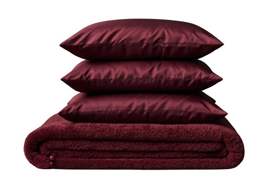 Stack of burgundy silk pillows and a plush fleece blanket, soft luxury bedding for comfortable sleep