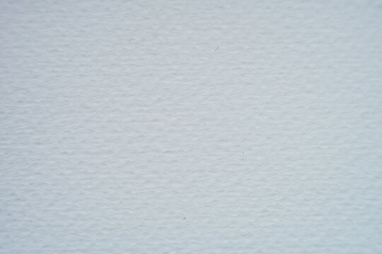 A high-resolution macro shot of white cold-pressed watercolor paper. 