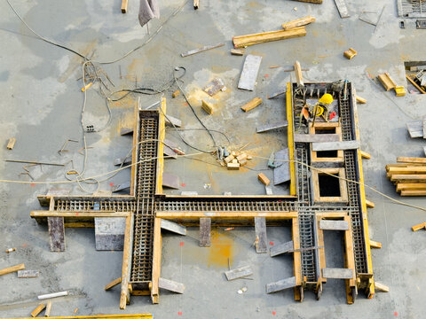 View of a construction site, where a worker in a yellow helmet is building a structure with wood, metal, and concrete, Avcilar/Istanbul, Istanbul, Turkey.