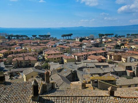 High angle view of Bolsena medieval town with red clay tile roofs and Lake Bolsena in the background, Lazio, Italy