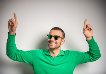 Naklejka premium Happy man pointing upward with both hands.