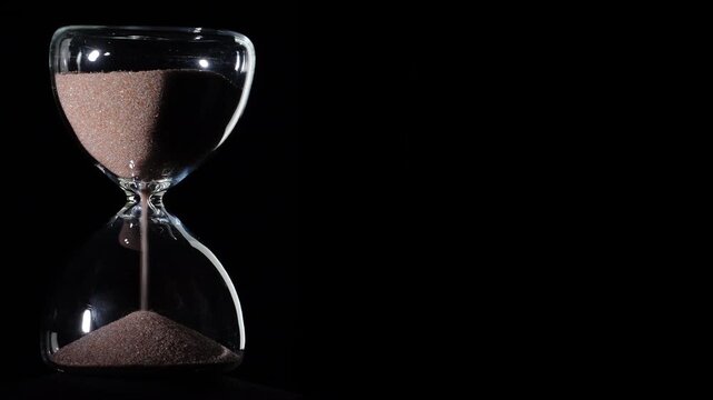 Hourglass flowing on black background. Left align composition with copy space on right, time management concept, minimalist product shot, hourglass in motion, clean style, steady flow
