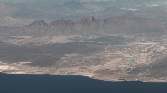 aerial view of Saudi Arabian landscape, south of Oxagon, Al Muwaileh, located at Red Sea coastline with Port of Neom, industrial plants and mountain desert landscape- 4k aerial video footage 
