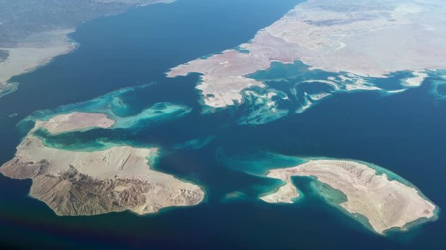flying along Sanafir Island , located in the Straits of Tirana which separates the Gulf of Aqaba from the Red Sea, with Ras Alsheikh Hamid an uninhabited headland on western tip of Saudi Arabia
