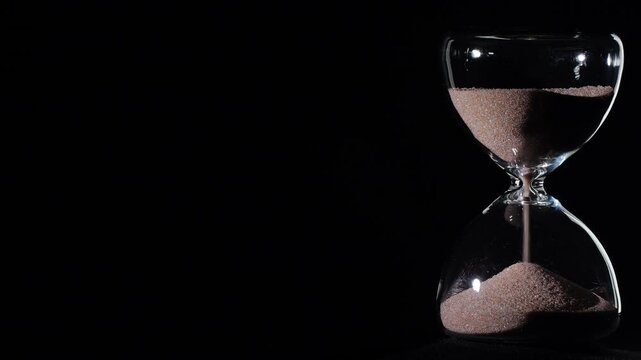 Hourglass flowing on black background. Right align composition with copy space on left, time management concept, minimalist product shot, hourglass in motion, clean style, approaching end
