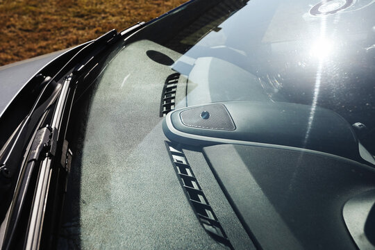 Car windshield with strong sunlight reflection. Transport concept. Vehicle interior background. Driving safety and visibility idea. Modern automobile detail for mobility travel and road use theme.