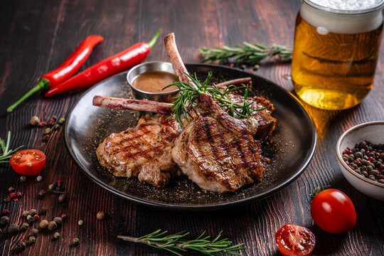 Grilled lamb chops with rosemary and beer on rustic table