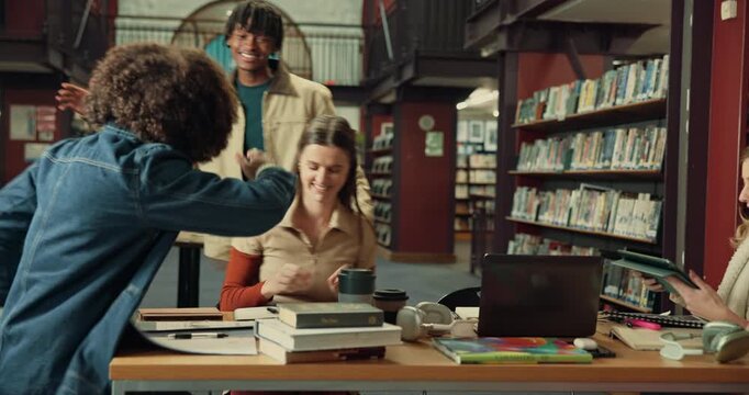 Students, friends and greeting with hug in library for welcome, handshake or study group. Education, gen z people and embrace at university for assignment support, morning routine and class tutorial